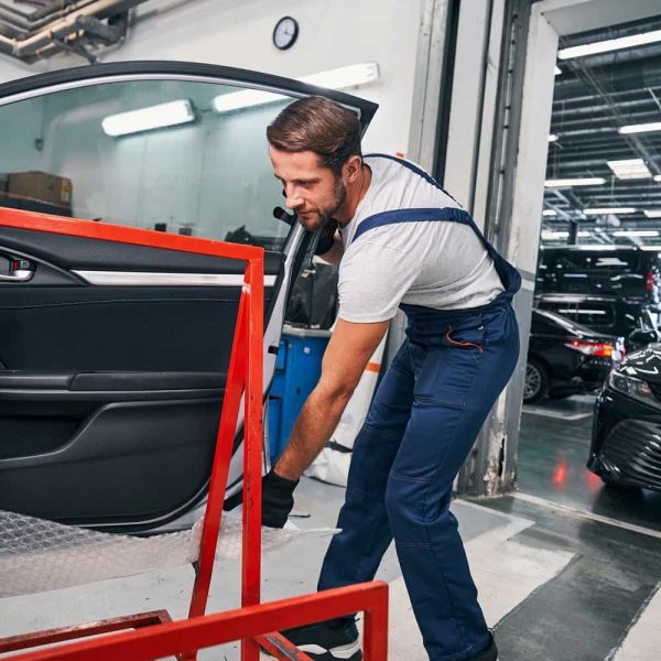 up-male-car-service-worker-placing-car-door-on-red-su-2021-09-08-07-23-34-utc-min.jpg